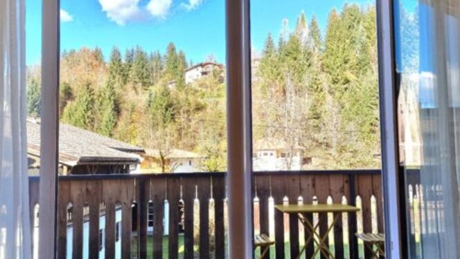 Fieberbrunn All Suites, Blick vom Balkon Blick aus dem Fenster auf die Bäume.