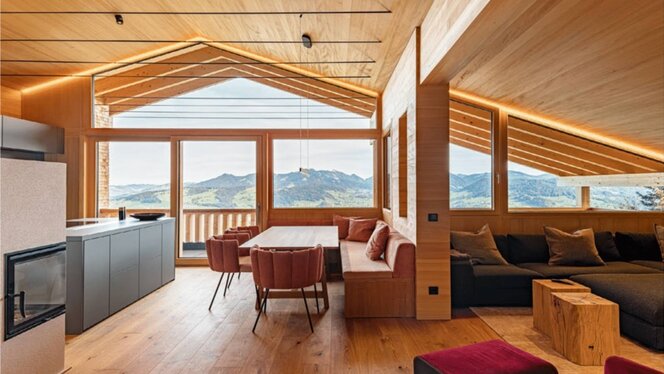 Gemütlicher Wohn- und Essbereich am Kamin Wohn- und Essbereich mit Kamin, Sitzbank und großem Bergblickfenster im Ferienchalet, Egg