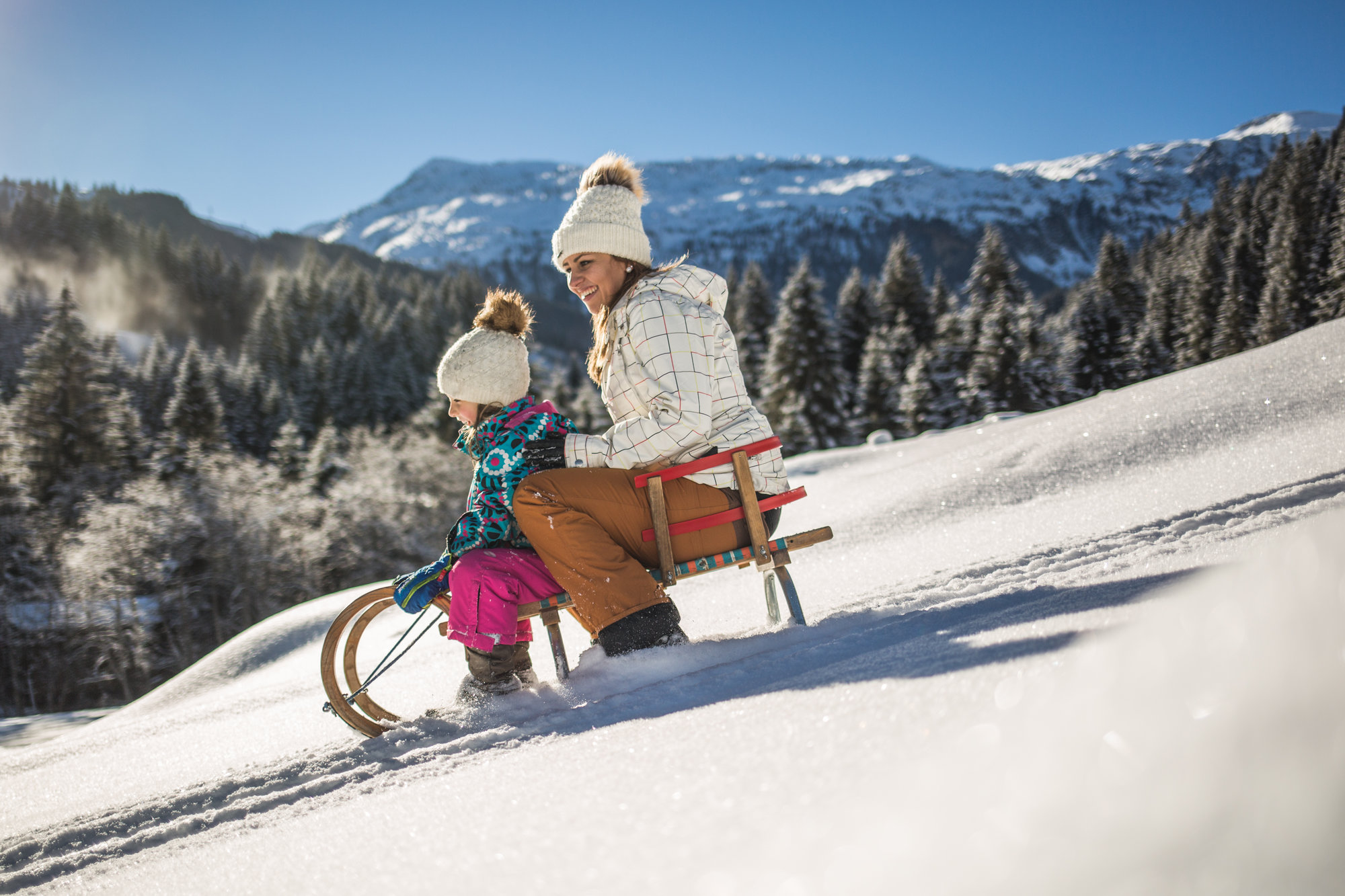 Kind mit Mutter auf Schlitten